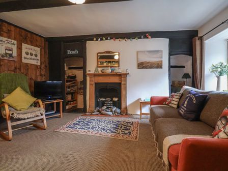 A living room with a fireplace a sofa and a chair at Church View in Lyme Regis