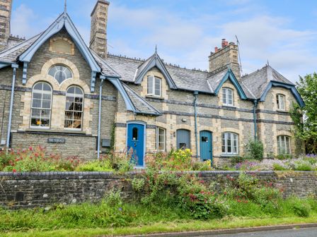 Stone terrace houses with blue doors windows and flower gardens in front at Teachers Cottage Presteigne