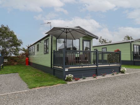 A mobile home with an outdoor deck and umbrella at Jean's Place in East Heslerton near West Heslerton