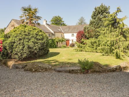 A house with a garden with grass and various trees and shrubs at 2 Yr Hen Felin Castle Morris near Letterston