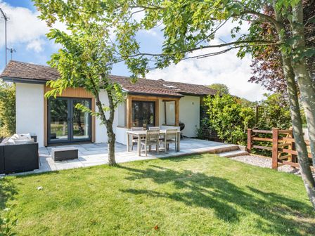 A patio with outdoor furniture and trees in a backyard at The Paddock in Honington near Shipston-On-Stour