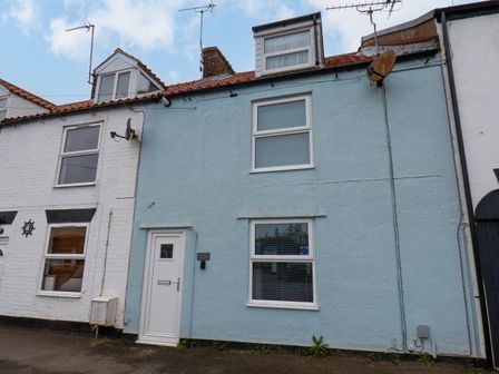 A row of two storey terraced houses with antennas and satellite dishes on the roofs at Bluebell Cottage in Flamborough