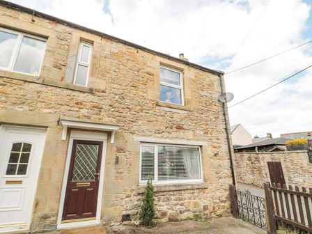 Stone house exterior with brown door white window and small front garden at 4 Tyne View in Wark