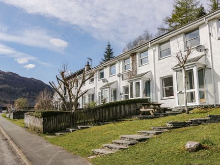 A row of white terraced houses with small front gardens and stairs leading to the entrances at Fellside View in Chapel Stile