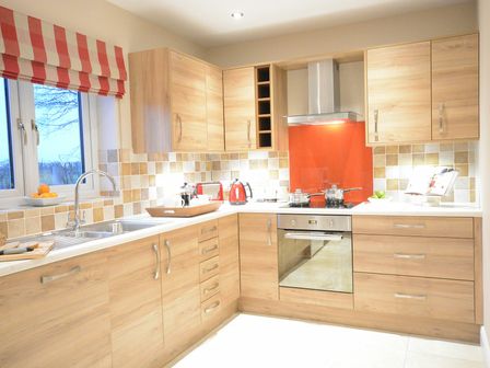 A kitchen with wooden cabinets a window and cooking utensils at Red Robin Whepstead in Wickhambrook near Bury St Edmunds
