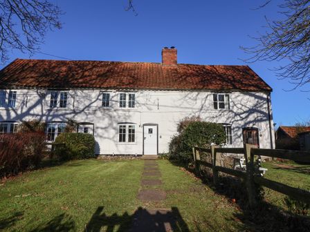 A white cottage with a tiled roof and a chimney in a garden at 2 Greensleeves Benhall Near Friston