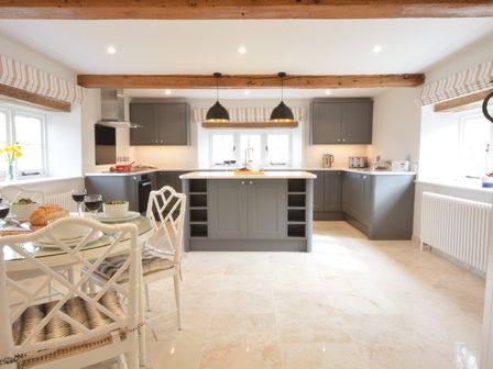 A kitchen with a central island and dining table with chairs at Woodland Cottage Great Glemham Near Framlingham