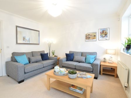A living room with two gray sofas and a wooden coffee table at Bluebelle Cottage Peasenhall