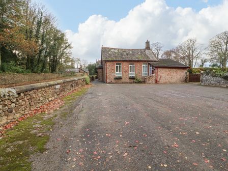 A small stone house with three windows and a chimney at Old School Muncaster House Ravenglass near Holmrook