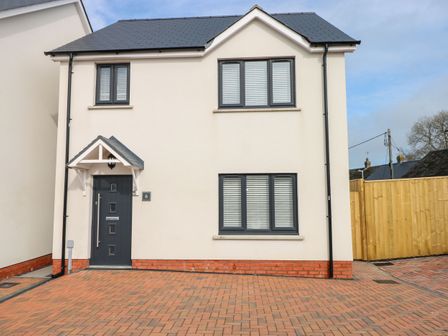 A two story house with three windows a front door and a brick driveway at LunaRoxx 6 Meadow Gardens Kilgetty