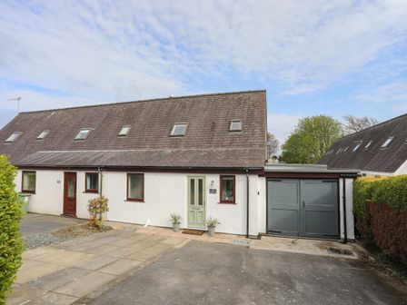 A semi detached house with front doors driveway and garage at 240 Cae Du in Abersoch