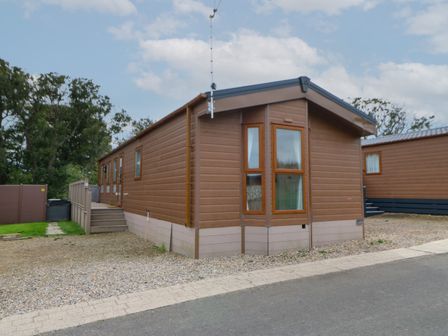 A brown mobile home with multiple windows and steps leading to a door at Bock Retreat in Felton