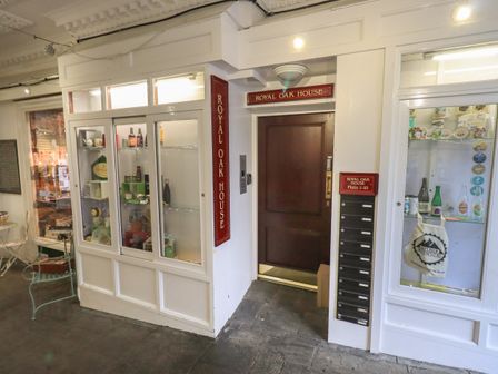 An entrance door to Royal Oak House with mailboxes and display cabinets on either side at Peak View in Keswick