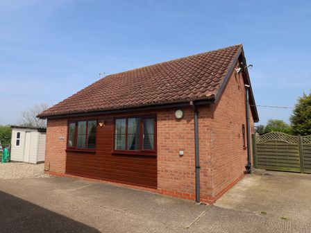 A single story brick house with tiled roof and windows along a driveway at Church View in Atwick