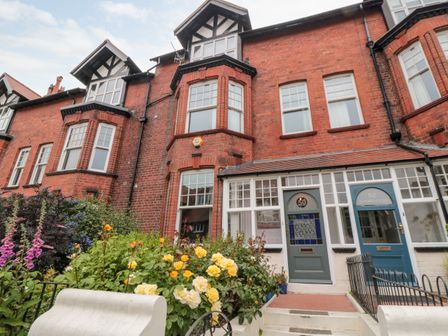 A red brick townhouse with bay windows and flower garden at 50 West Street Edelweiss Scarborough