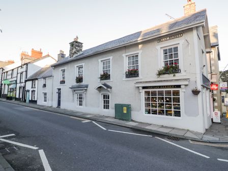 A street view of buildings including Tan Lan Bakery with window boxes on upper windows at Sea Chest in Conwy