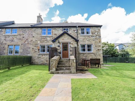 A house with lawn and patio seating at Crispin in Lucker