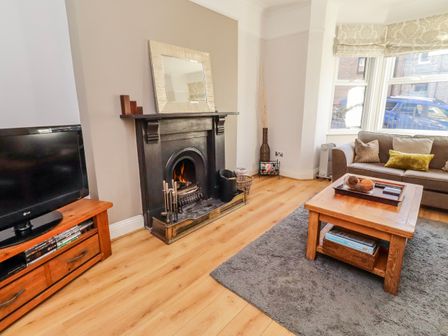 A living room with a fireplace and television at Alnbank in Alnmouth
