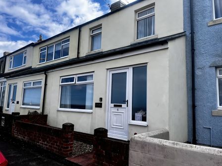 The exterior of a house with a front door and windows at Bay View in Amble