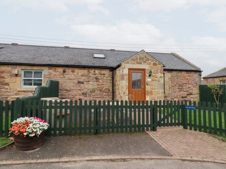 An outdoor area with a stone wall and door at Chiff Chaff in Lucker