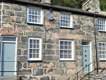 Exterior of a stone house with windows and a door at Ty Driffter in Tremadog