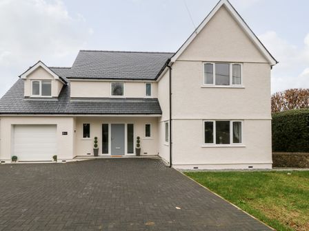 A two-story house with a paved driveway and a garage at White Bull House in Amlwch
