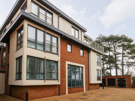 A multi story residential building with large windows and a gravel driveway at Pointers View in Weymouth