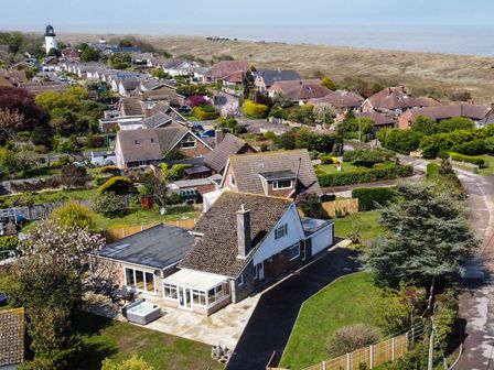 A residential area with houses gardens and a lighthouse near the coast at Fallowfield in Winterton-On-Sea