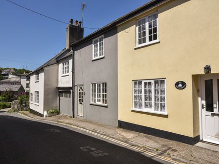A row of houses with different colored facades and windows along a street at 21 Mill Green in Lyme Regis