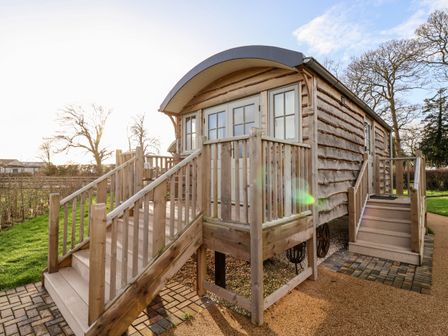 An exterior view of a wooden cabin with two sets of stairs and a small porch at Amy Johnson in Bolton Percy near Tadcaster