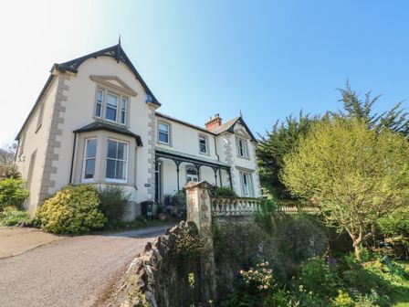 A large two-story house with a garden and driveway at The Outlook in Minehead