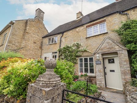 Stone cottage with a garden and greenery at Lynton Cottage in Enstone