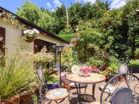 A patio area with a table and chairs at Turnpike Lodge in Brixham