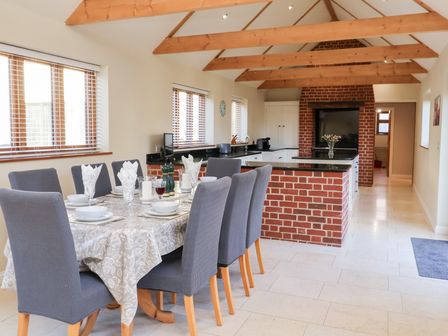 A kitchen with a dining area and a breakfast bar at The Stables at Hall Barn Wattisfield near Walsham-Le-Willows