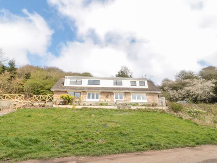 A detached house with multiple windows and a sloped grassy front garden at Whiteadder Bank in Berwick-Upon-Tweed