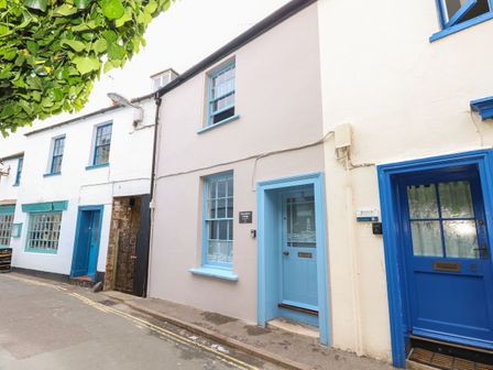 Exterior view of a street with buildings featuring blue framed windows and doors at Riverdance Cottage in Lyme Regis