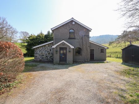 A two story house with a gravel driveway and a shed in a rural area at Ysgubor Wen in Llanrwst