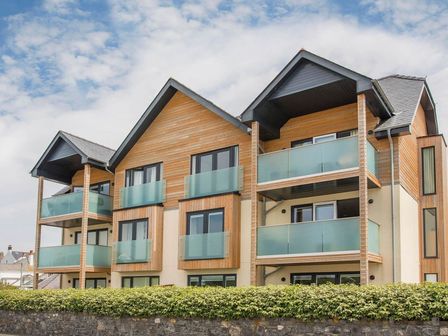 A modern apartment building with balconies and glass railings at 4 Y Bae in Trearddur Bay