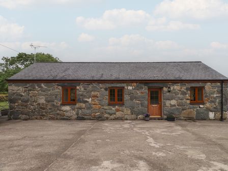 A stone cottage with windows and a door at Bryn Caled in Llanarmon near Y Ffor