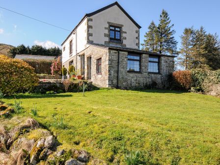 A stone and plaster two-story house with a grassy garden and trees at Bickle Bice Cottage Minions near Liskeard