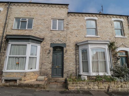 A brick terraced house with two bay windows and a dark green door numbered 13 at Top-Notch Flat in Saltburn-By-The-Sea