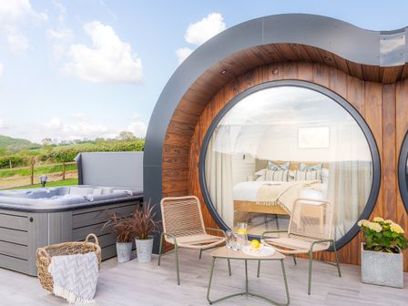 An outdoor area with a hot tub and seating at Ceunant in Llanfihangel-y-Creuddyn near Aberystwyth
