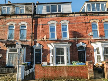 A brick terraced house with white window frames and a bay window at Bay House in Bridlington