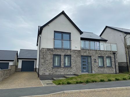 A two-story house with stone and white exterior walls a driveway and garage at Galwad y Mor in Broad Haven