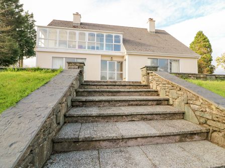 A house with large windows and stone steps leading up to it at Roughty Bridge View in Roughty Bridge near Kenmare County Kerry