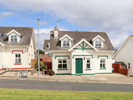 A street view of houses with dormer windows and green and red trim at South Beach in Duncannon County Wexford