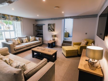 A living room with sofas armchair coffee table and lamps at Greta House in Keswick