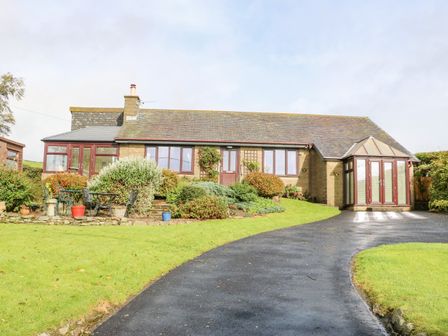 A bungalow house with a garden and patio furniture on a driveway at Pinegarth in Catton near Allendale