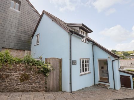A blue cottage with wooden gate and paved path at November Cottage in Dittisham