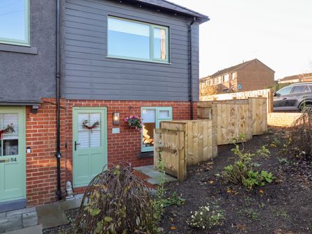 An outdoor area with a wooden fence and door at Nene's Nest in Alnwick